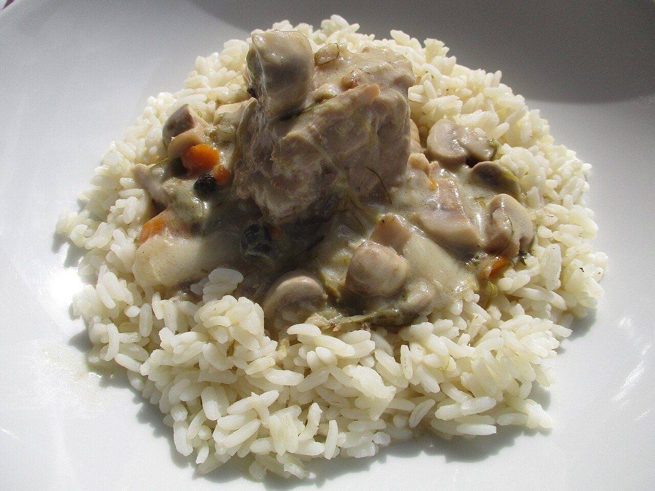 Blanquette de veau à l'ancienne com cogumelos e cenoura sobre arroz branco