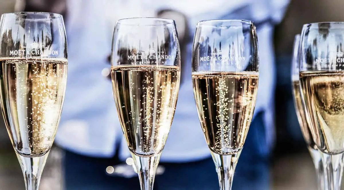 Taças de champanhe Moët & Chandon cheias, com bolhas subindo, em fila